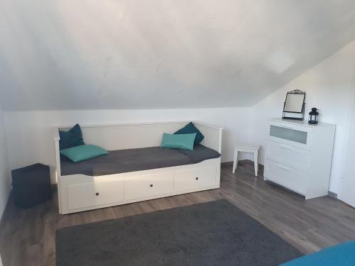 a white bed with blue pillows in a room at Möwe 7 in Grömitz