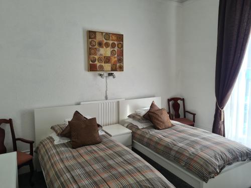 una camera con due letti con cuscini sopra di Maon Hotel a Brighton & Hove