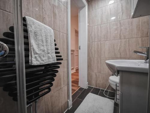 un bagno con lavandino e asciugamano appeso a un muro di LUXURIOUS 3 BEDROOM APARTMENT: HEART OF WESTEND a Glasgow