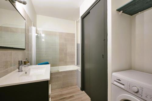 une salle de bain avec un lavabo et une machine à laver dans l'établissement Tout confort ! Climatisation, Centre-ville, Parking, Terrasse, WiFi, Netflix, à Carcassonne