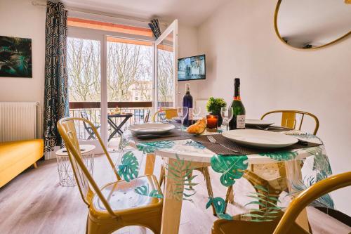 - une salle à manger avec une table, des chaises et des bouteilles de vin dans l'établissement Tout confort ! Climatisation, Centre-ville, Parking, Terrasse, WiFi, Netflix, à Carcassonne