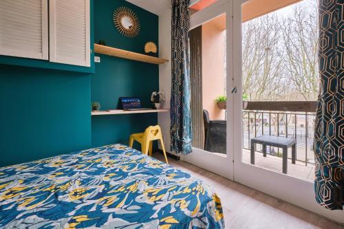 une chambre avec un lit avec un mur bleu dans l'établissement Tout confort ! Climatisation, Centre-ville, Parking, Terrasse, WiFi, Netflix, à Carcassonne