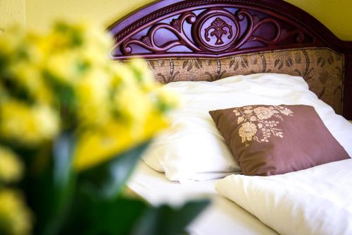 uma cama com uma almofada castanha e almofadas brancas em City Hotel UNIO superior em Budapeste