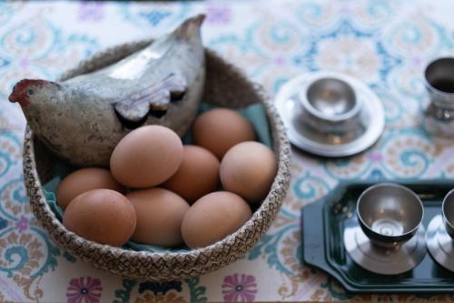 a basket of eggs sitting on a table with a chicken at Hotel Punto Verde in Marina di Campo