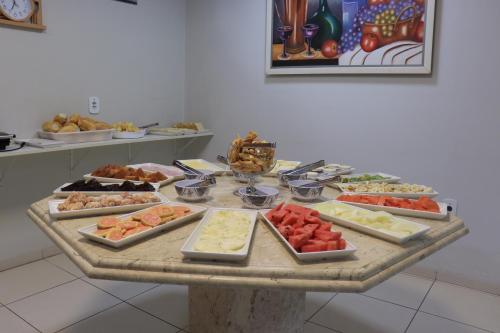 uma mesa com muitos tipos diferentes de comida em Hotel Bianchi em Primavera do Leste