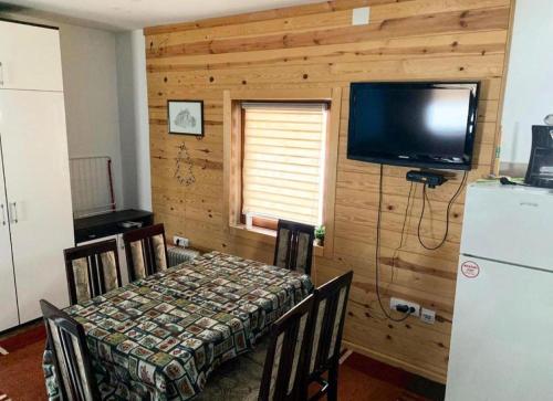 a dining room with a table and a flat screen tv at Apartman Tanja in Kopaonik