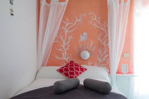 a bedroom with a bed with a red wall at Hotel Punto Verde in Marina di Campo