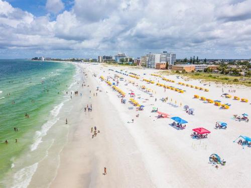 a beach with people and umbrellas and the ocean at Beach Haven in South Clearwater Beach in Clearwater Beach