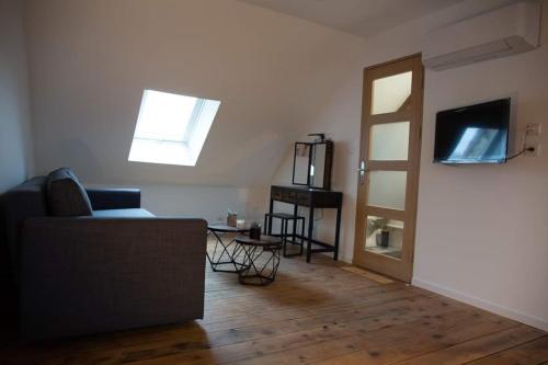 a living room with a couch and a flat screen tv at CYRIS - Chambres Duplex climatisées - Spa & Piscine Centre ville in Saint-Germain-des-Fossés