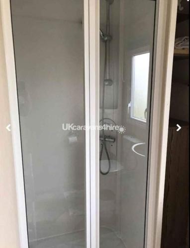 a glass shower door in a bathroom at Caravan Primrose Valley WW in Hunmanby