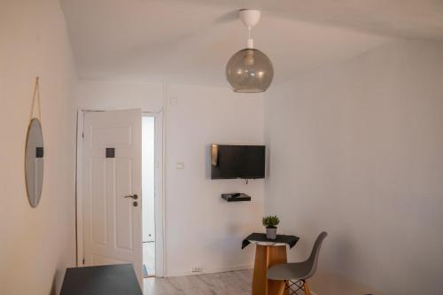 a living room with a chair and a tv on the wall at Moon Hostel Warszawa in Warsaw