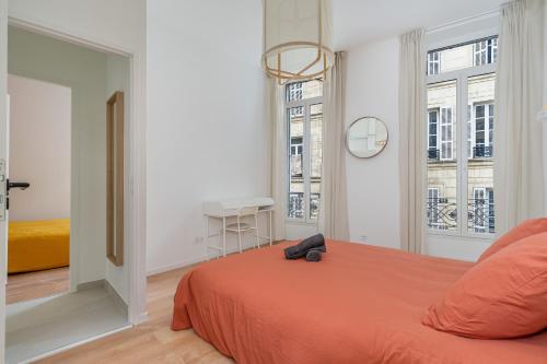 - une chambre avec un lit orange et un miroir dans l'établissement Spacieux T3 climatisé - Saint Charles & Vieux Port, à Marseille