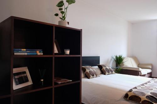 Schlafzimmer mit Bücherregal und Bett in der Unterkunft Boavista Studio 99 & Garage in Porto