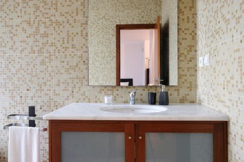 ein Bad mit einem Waschbecken und einem Spiegel in der Unterkunft Boavista Studio 99 & Garage in Porto