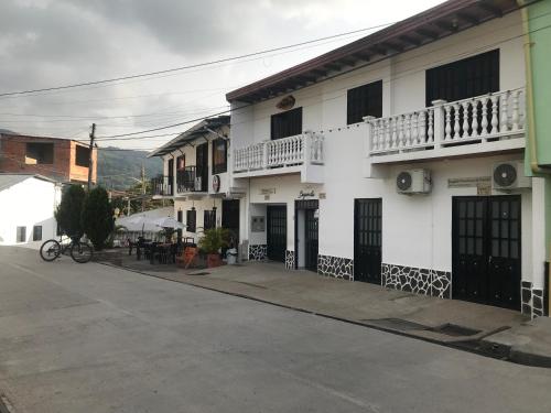 a white building with black doors and windows at Hotel Buganvilla in Guaduas