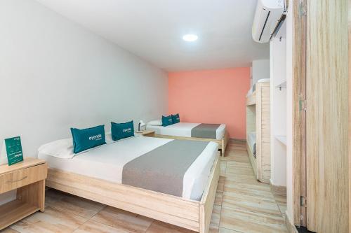 a bedroom with two beds and a tv in it at Ayenda Malaki in Medellín