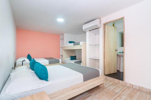 a bedroom with a large bed with blue pillows at Ayenda Malaki in Medellín