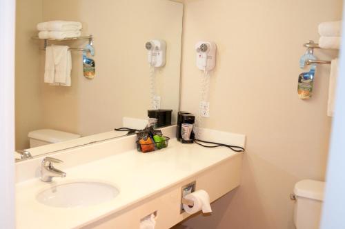 a bathroom with a sink and a mirror at Lamplighter Inn & Suites in San Luis Obispo