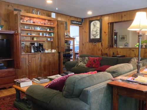a living room with two couches and a tv at The White House Inn in Cooperstown