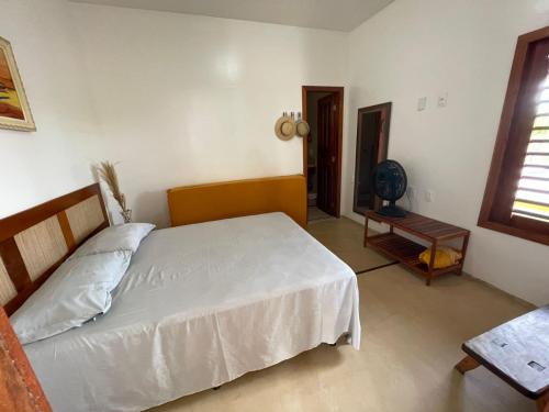 福廷的住宿－Recanto Casa de Mila，卧室配有白色的床和桌子