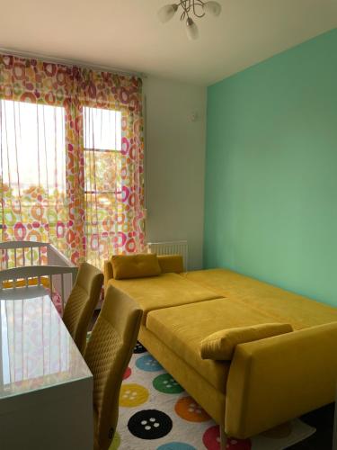a bedroom with a bed and a table and windows at D-S Apartman Stella in Zamárdi