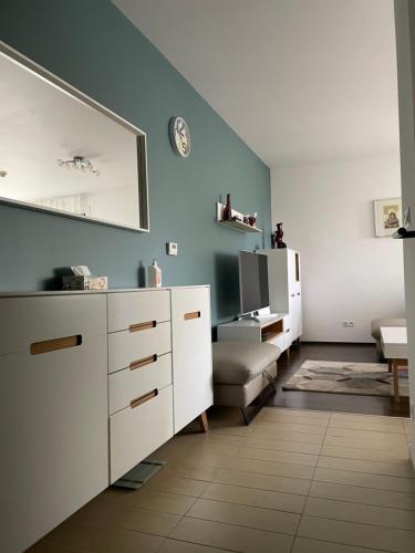 a living room with a white cabinet and a mirror at D-S Apartman Stella in Zamárdi