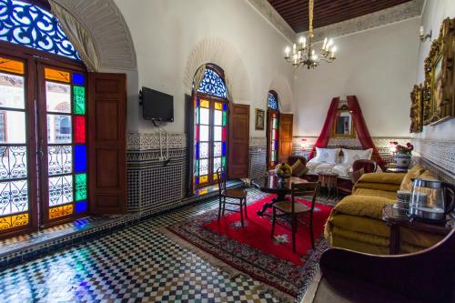 a living room filled with furniture and a large window at Riad Damia in Fez