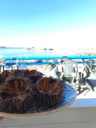 巴勒摩的住宿－Teatro del Sole Mare Sferracavallo，海滩附近的一张桌子上有一个蓝色的盘子,上面有两只榴莲