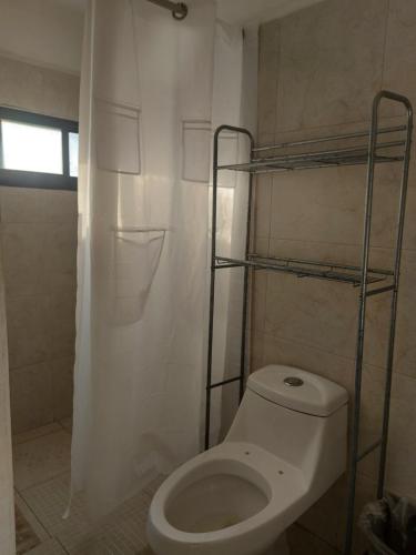 y baño con aseo y cortina de ducha. en EL ANCLA, en Ciudad del Carmen