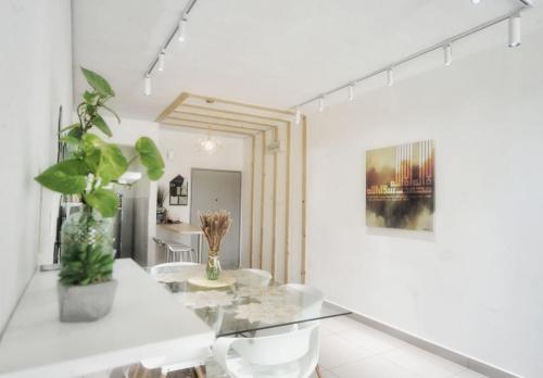 a white dining room with a glass table at zara1881 muslim homestay@putrajaya in Putrajaya