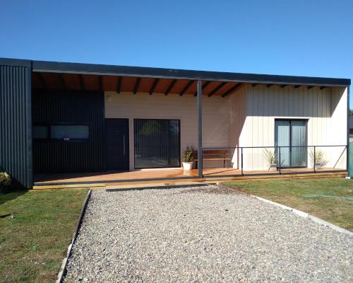a house with a black roof and a patio at Complejo Del Este Suites in San Carlos de Bariloche