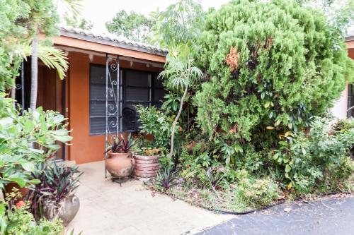a house with a bunch of plants in front of it at Comfortable Home, 7 min Walk to Beach, Hot Tub, in Pompano Beach