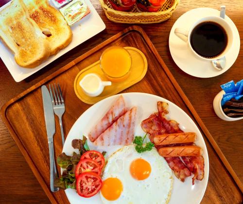 een bord ontbijtproducten met eieren, spek en toast bij Nalanta Hotel Pattaya in Pattaya