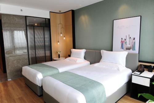 deux lits dans une chambre d'hôtel avec dans l'établissement Dexin Fuyuan Hotel, à Xiaoshan