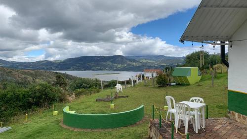 a patio with a table and chairs and a view of a lake at La Estación de Tomine in Guatavita