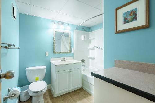 a blue bathroom with a toilet and a sink at Ocean Key Resort by VSA Resorts in Virginia Beach
