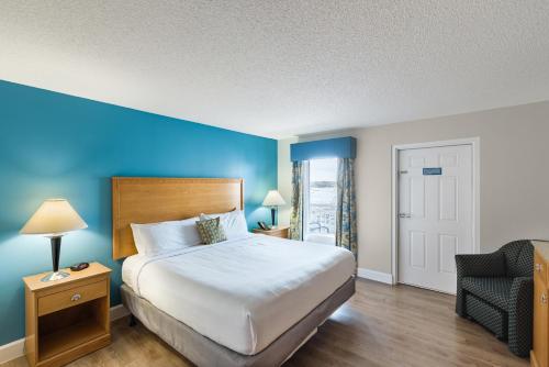 um quarto de hotel com uma cama e uma cadeira em Ocean Key Resort by VSA Resorts em Virginia Beach