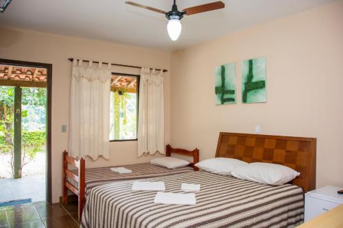 two beds in a room with two windows at Hotel Fazenda Monte Sião in Monte Sião