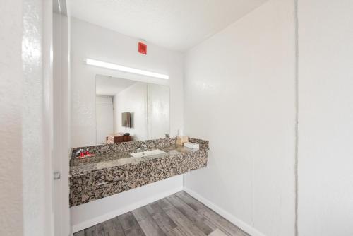 a bathroom with a sink and a mirror at Econo Lodge Inn & Suites Near Bricktown in Oklahoma City
