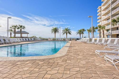 einen Pool mit Stühlen und Palmen sowie ein Gebäude in der Unterkunft Seaside Beach and Raquet Club Condos III in Orange Beach