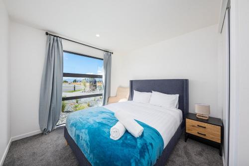 a bedroom with a large bed and a window at Tekapo Top 1000 Apartment in Lake Tekapo