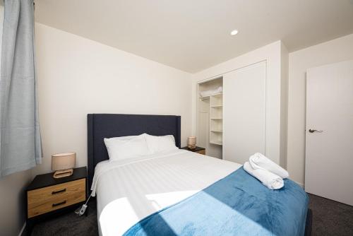 a bedroom with a large bed with a blue blanket at Tekapo Top 1000 Apartment in Lake Tekapo