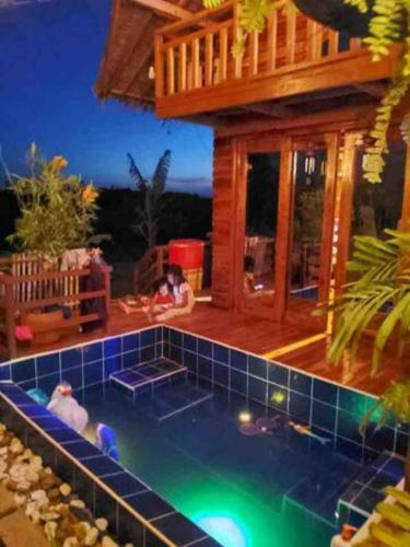 una casa con piscina frente a una casa en Rancho Oco Mahogany Loft Type Villa en Nasugbu