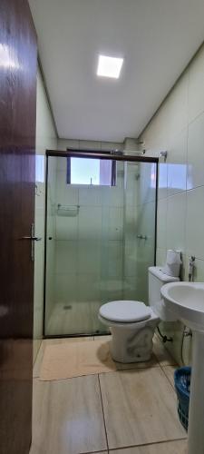 a bathroom with a shower and a toilet and a sink at Hotel Arterial in Foz do Iguaçu