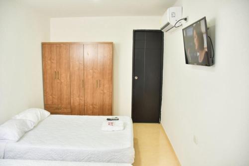 a bedroom with a bed and a wooden door at Hotel Daniels in Fonseca