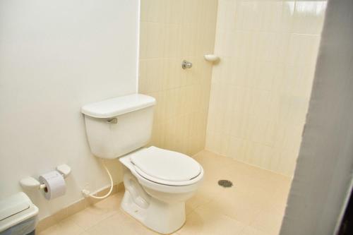 a bathroom with a white toilet and a shower at Hotel Daniels in Fonseca