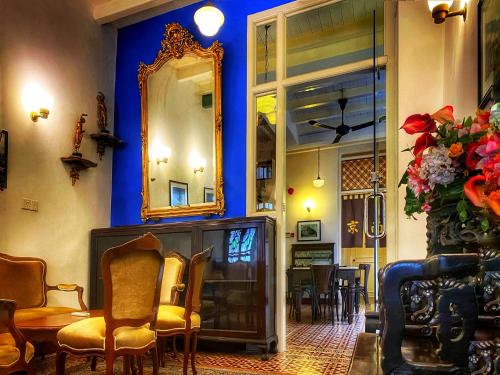 a room with a mirror and a table and chairs at Nam Keng Hotel Penang in George Town