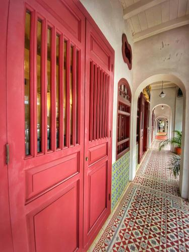 a red door in a hallway with a tile floor at Nam Keng Hotel Penang in George Town