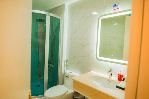 a bathroom with a shower and a toilet and a sink at Hoa Đông Aureum Hotel Hà Nam in Châu Cầu