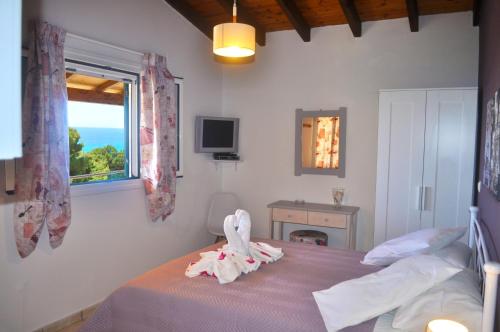 a bedroom with a bed and a window at Villa Takis on Pelekas beach Small house with garden and sea view in Pelekas